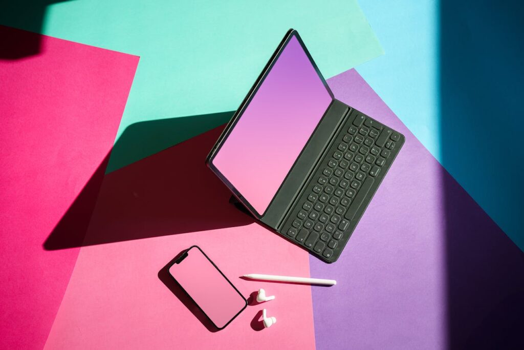 pexels-photo-17561470 Vibrant flat lay featuring a tablet, smartphone, and stylus on a colorful background.